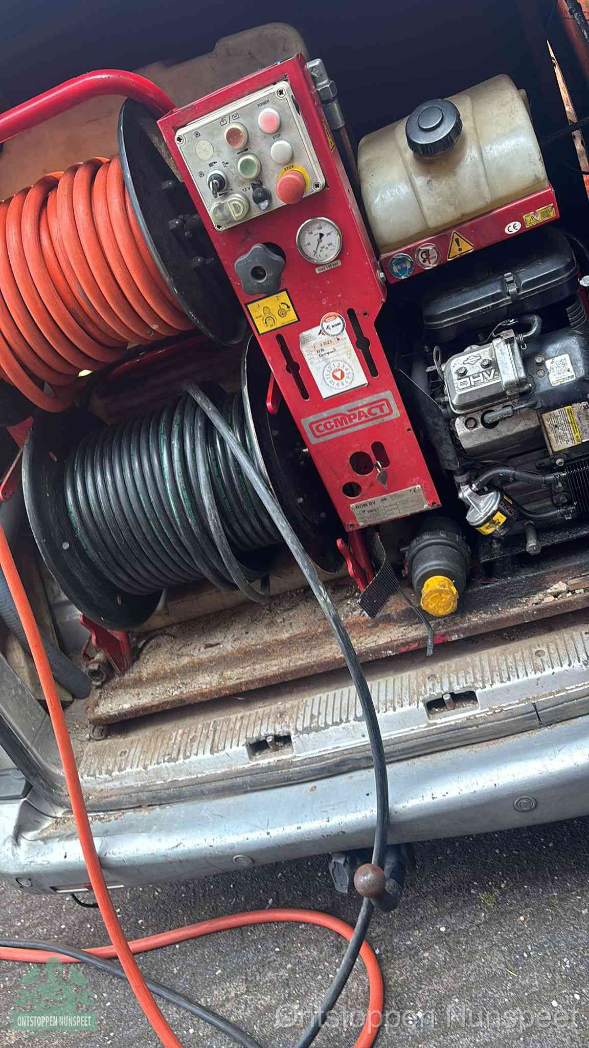 Een rood hogedruk-rioolreinigingstoestel met slangen in de laadbak van de bedrijfsbus, apparatuur voor een hardnekkige wc-verstopping in Nunspeet