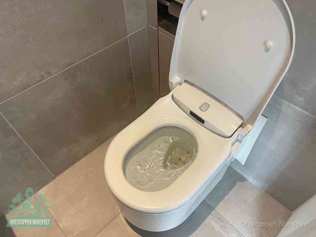 Een toiletpot vol troebel water met drijvend papier en restanten, de meest voorkomende oorzaak van een verstopte wc in Nunspeet