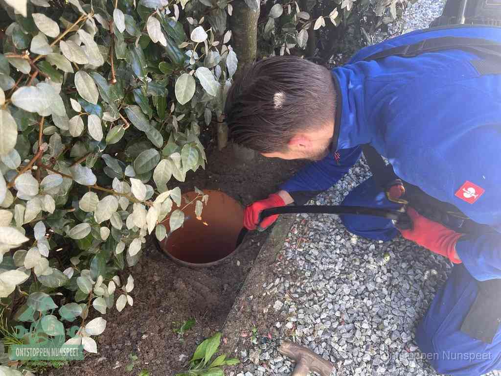Monteur reinigt een rioolput met een slang, periodieke rioolreiniging in Nunspeet