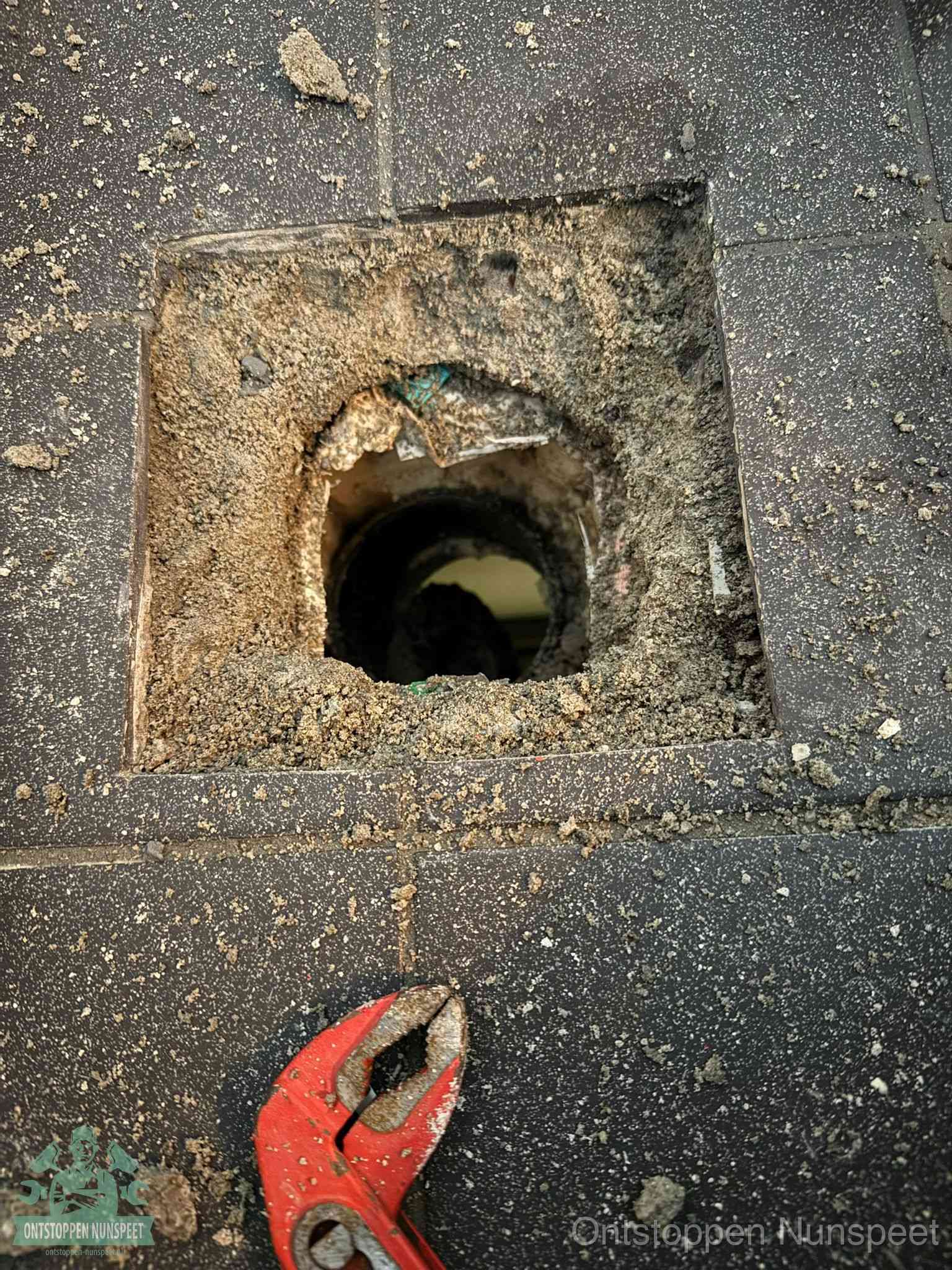 Geopend rioolputje op de erfgrens dat laat zien wie eigenaar is van de riolering in Nunspeet