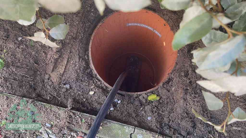 Open inspectieput in de tuin waar een veer rioolvliegjes en stankoverlast aanpakt in Nunspeet
